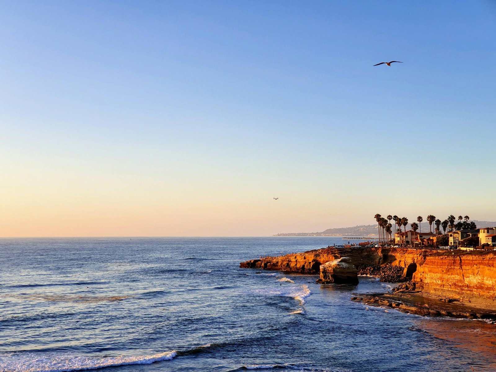 Breathtaking view of the San Diego coast at sunset, featuring cliffs and a tranquil ocean.